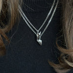 Close-up of silver BFF necklace with winged heart pendant