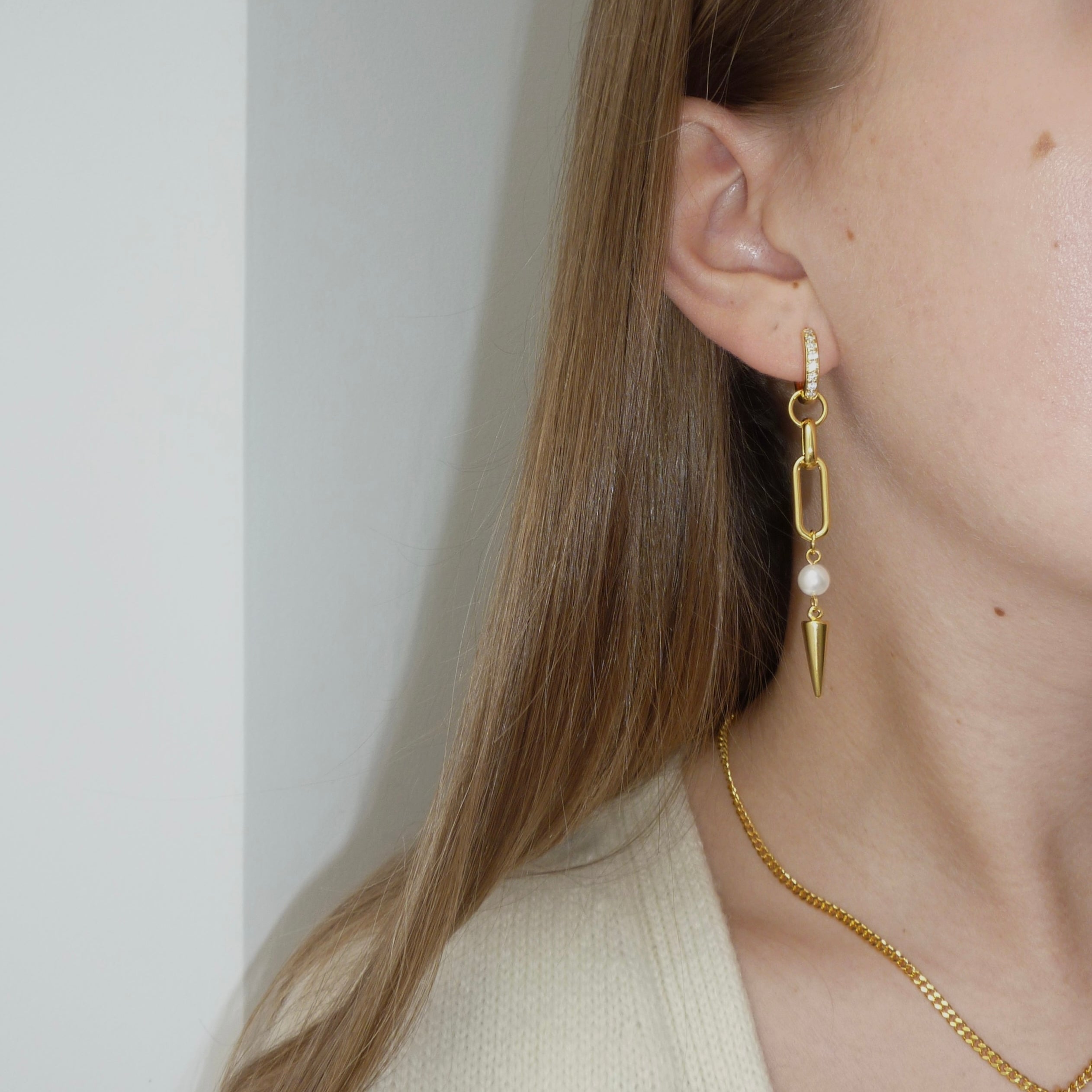 Adora Earrings in gold worn with heart necklace, close-up side view