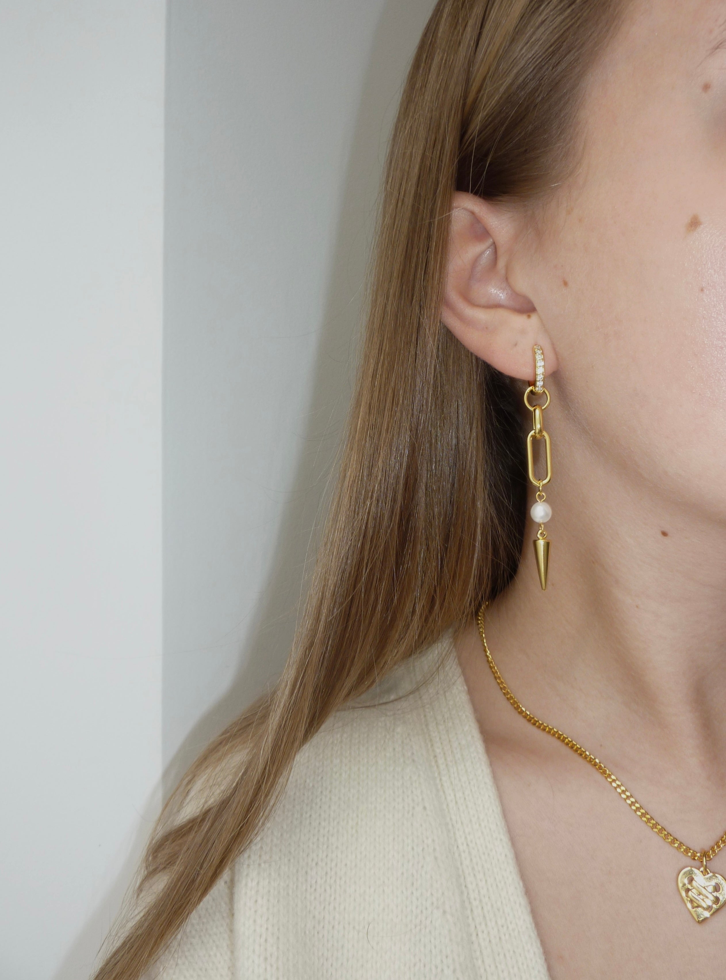 Adora Earrings in gold worn with heart necklace, close-up side view