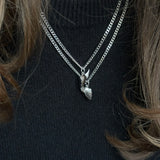 Close-up of silver BFF necklace with winged heart pendant
