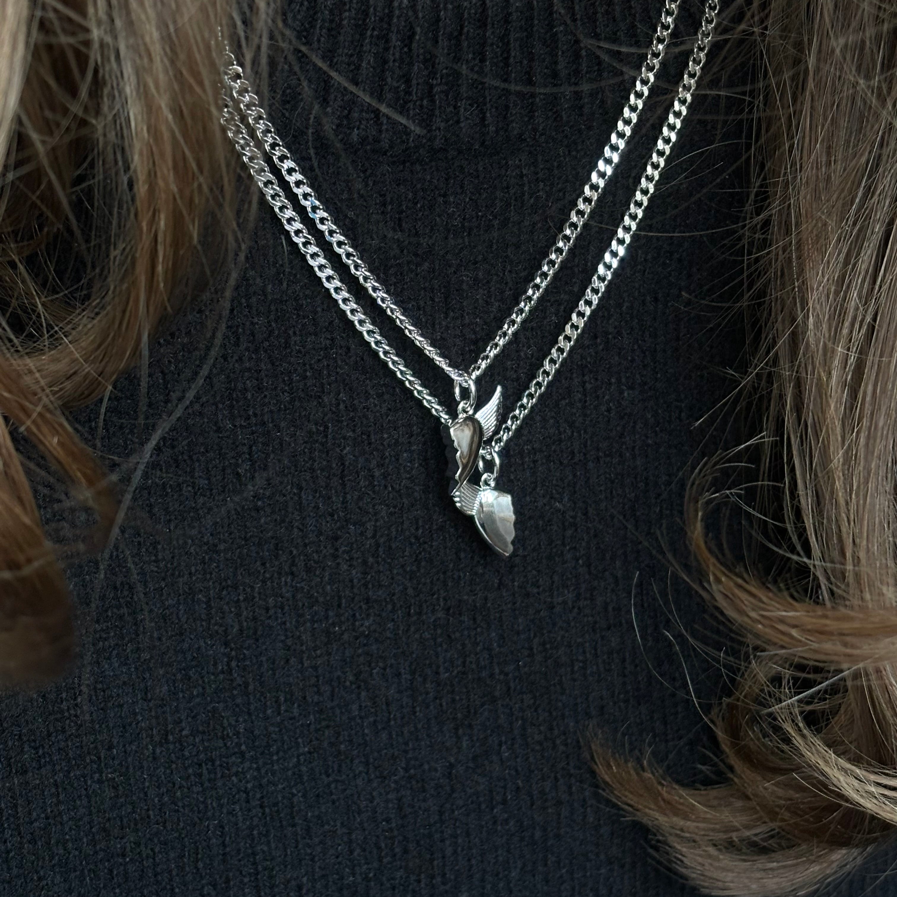 Close-up of silver BFF necklace with winged heart pendant
