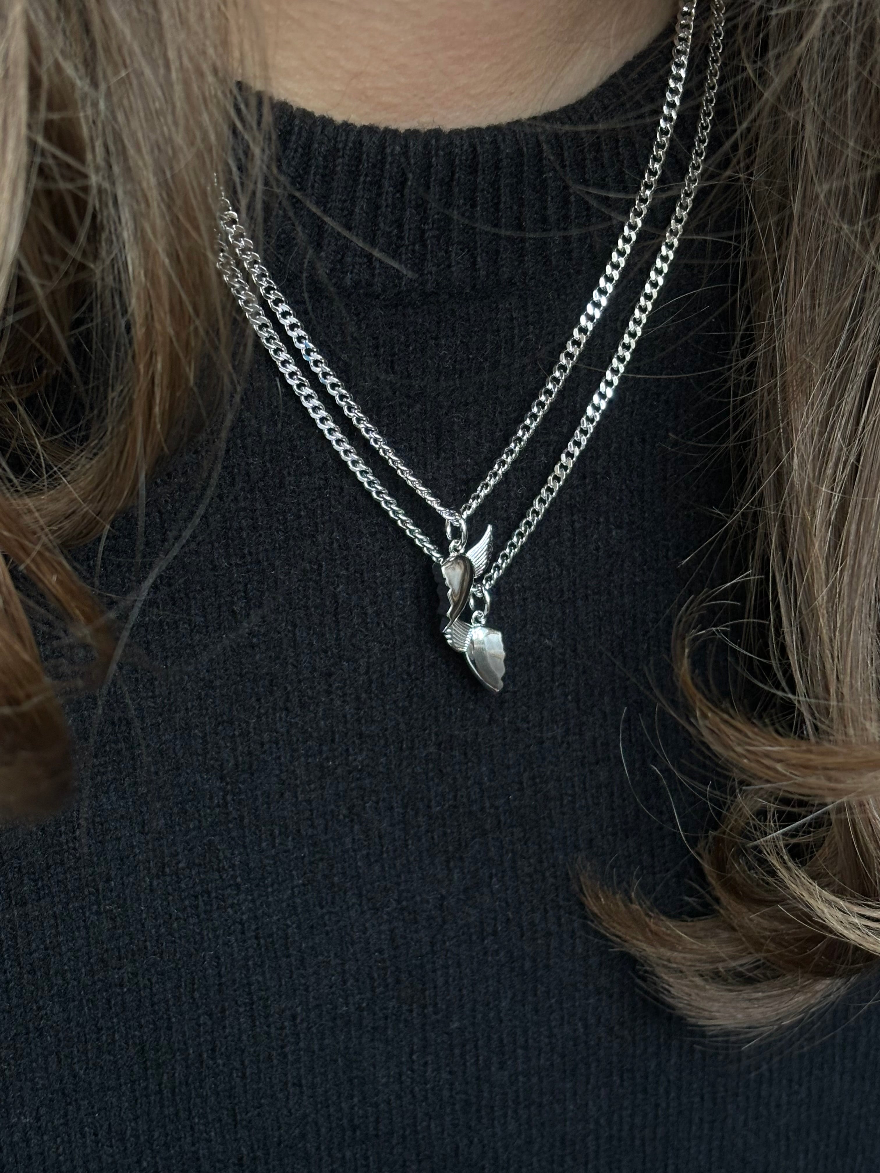 Close-up of silver BFF necklace with winged heart pendant